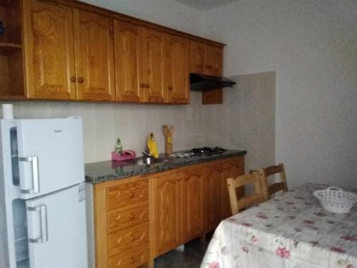 a kitchen with wooden cabinets and a white refrigerator at Apartamento Bello Bello in Valle Gran Rey