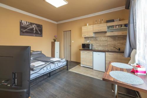 a living room with a bed and a kitchen at Ivanhoe Apartman in Nyírbátor