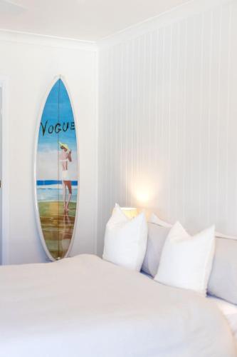 a bedroom with a bed and a surfboard on the wall at Finns at Old Bar in Old Bar