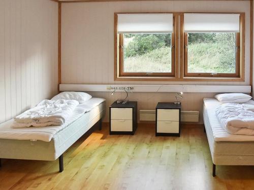 two beds in a room with two windows at 12 person holiday home in Oksvoll in Oksvoll