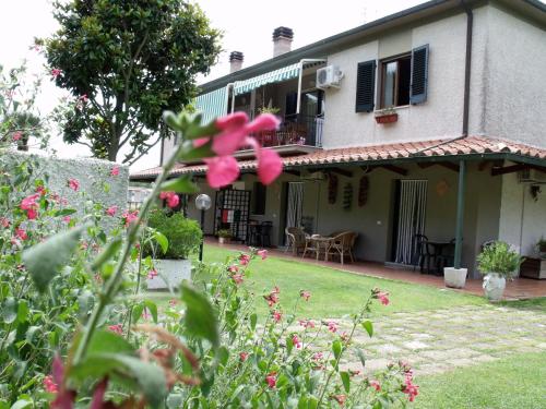 a house with pink flowers in the yard at Villa Isabella in Marina di Grosseto