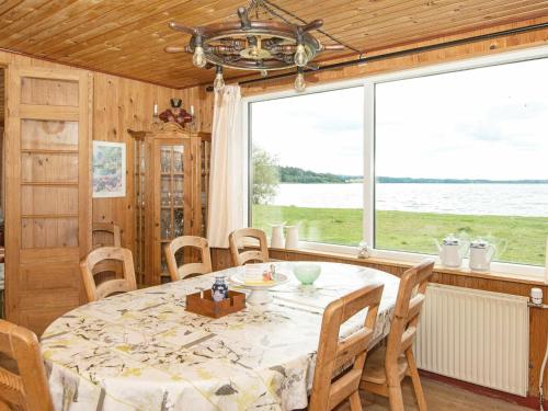 a dining room with a table and a large window at Lakefront Retreat in Sohojlandet - By Traum Ferienwohnungen in Skanderborg