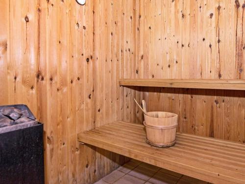 a wooden sauna with a bucket on a wooden shelf at Lakefront Retreat in Sohojlandet - By Traum Ferienwohnungen in Skanderborg