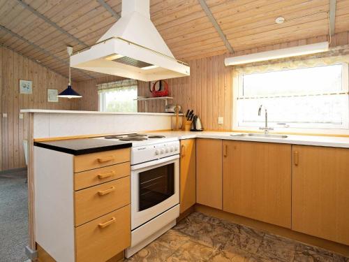 a kitchen with a stove and a sink at 8 person holiday home in Stege in Stege