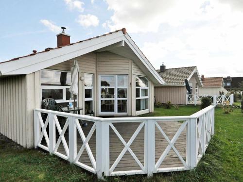 una casa con un porche con una valla blanca en 4 person holiday home in Gelting, en Gelting