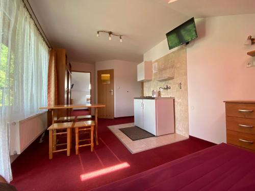 a small kitchen with a table and a counter at Willa Carmen in Krynica Zdrój