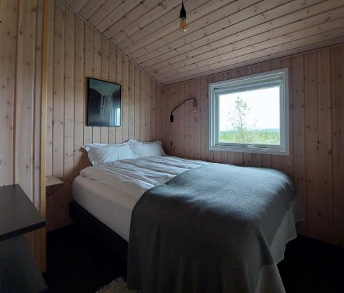a bedroom with a large bed in a room with a window at Hilltop Cabin Hekla - Golden Circle - Geysir - Mountain View in Reykholt