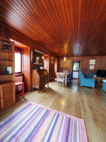 a living room with a wooden ceiling and a rug at Casa de Castro Laboreiro in Castro Laboreiro