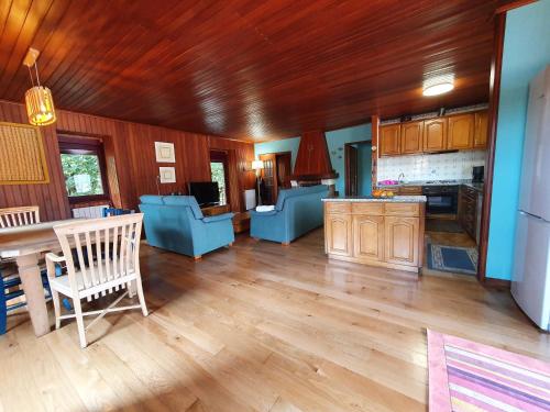 a large living room with a table and blue chairs at Casa de Castro Laboreiro in Castro Laboreiro