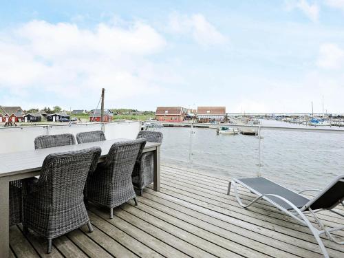 a dock with chairs and a table and the water at 6 person holiday home in Hemmet in Falen