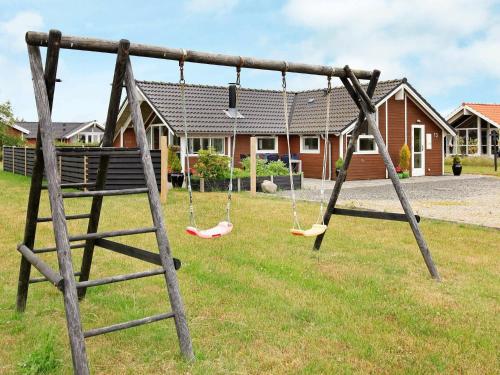 a swing set in a yard with a house at Luxury Spa Retreat by Bork - By Traum Ferienwohnungen in Hemmet