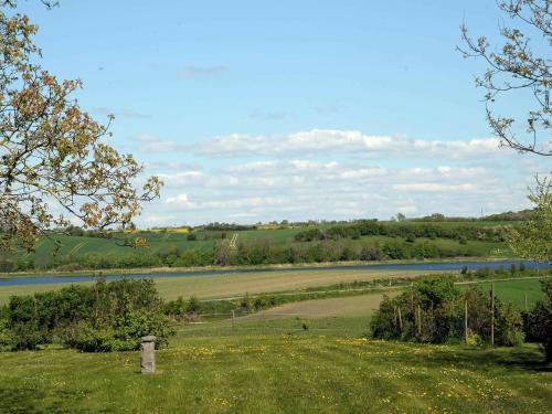 ノーポにある10 person holiday home in Nordborgの川を背景にした畑の眺め