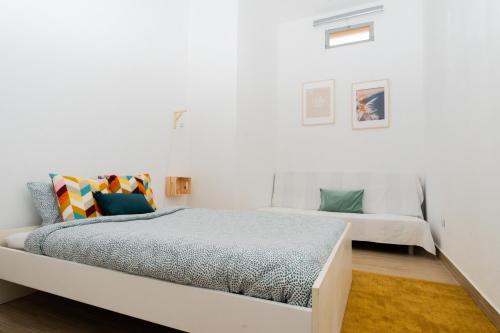 a bedroom with two beds and a white wall at Casa da Felicidade Nazaré in Nazaré