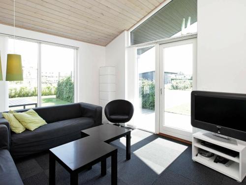 a living room with a couch and a tv at 8 person holiday home in Haderslev in Årøsund