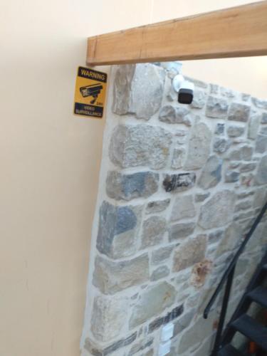 a stone wall with a sign on it at Chalkidιό in Pitsidia