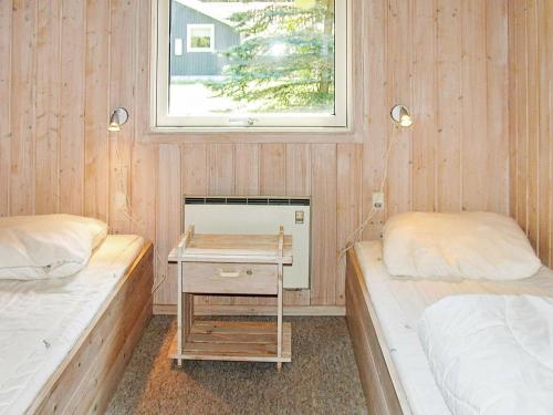 a room with two beds and a table with a window at Holiday home Idestrup in Marielyst