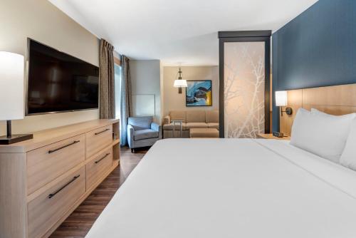 a hotel room with a large bed and a flat screen tv at Hyatt Place Indianapolis Carmel in Carmel