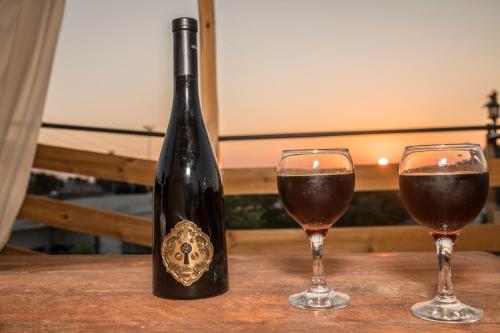 a bottle of wine and two glasses on a table at Chalkidιό in Pitsidia