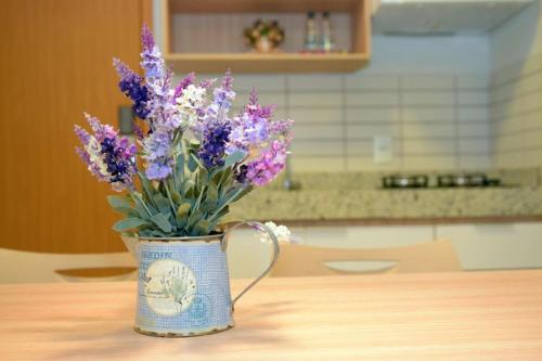 un vase rempli de fleurs violettes sur une table dans l'établissement 304 Flat Edifício Everest, à Caldas Novas