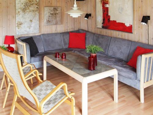 uma sala de estar com um sofá, uma mesa e cadeiras em 6 person holiday home in L kken em Grønhøj