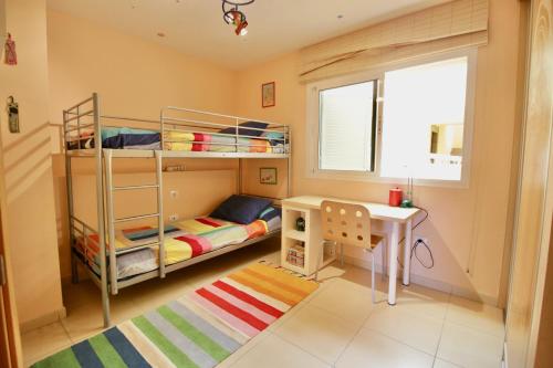 a small room with bunk beds and a desk at Ohana Vista Mar Los Abrigos in Los Abrigos