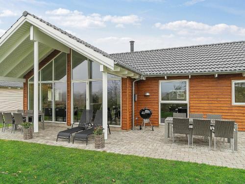 a patio with chairs and tables in front of a house at 10 person holiday home in Hasselberg in Kappeln
