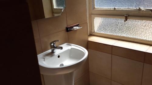 a bathroom with a sink and a window at The Shakespeare Inn in Vanderbijlpark