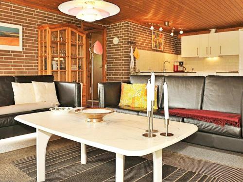 een woonkamer met een tafel en een bank bij 4 person holiday home in Henne in Henne Strand