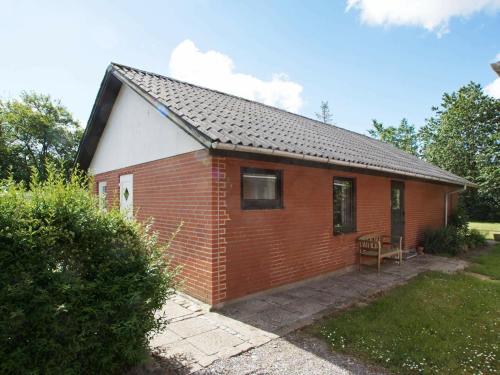 a small red brick house with a table in a yard at 6 person holiday home in Hemmet in Falen