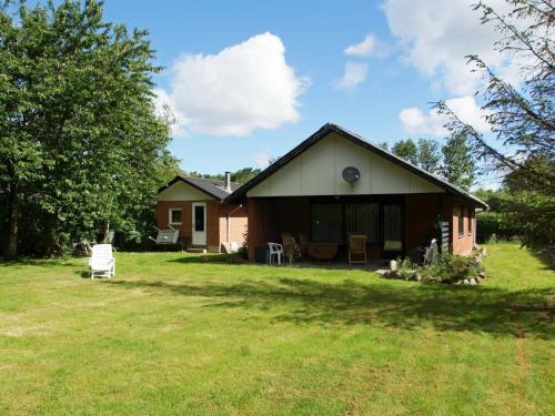 a small house in a yard next to a field at 6 person holiday home in Hemmet in Falen