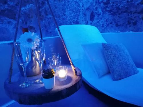 a blue room with a bed with a table with candles and glasses at Mastrangelo Suite & Spa in Palermo