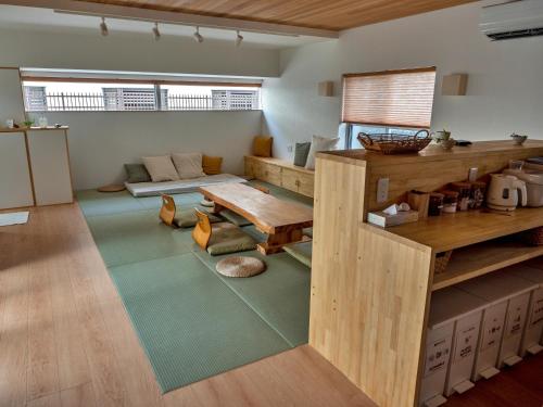 石垣島にあるGuest House Ishigakiの広いリビングルーム(テーブル、ソファ付)