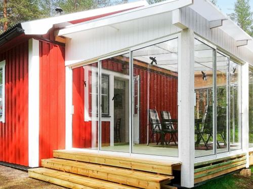una pantalla en el porche de una casa roja y blanca en 6 person holiday home in STMARK en Kristinefors