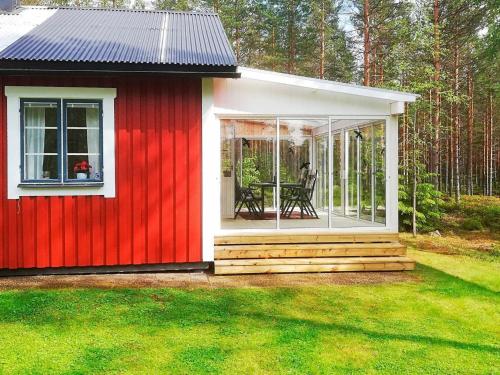 un cobertizo rojo y blanco con una mesa. en 6 person holiday home in STMARK en Kristinefors