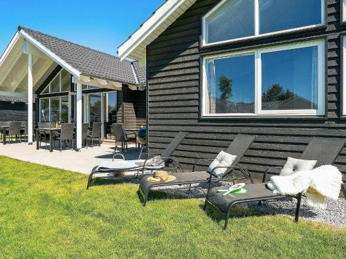 a backyard with chairs and tables and a house at 16 person holiday home in Hasselberg in Kappeln