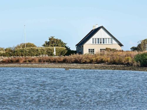 une maison sur la rive d'une masse d'eau dans l'établissement 4 person holiday home in Bogense, à Bogense