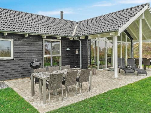 eine Terrasse mit einem Tisch und Stühlen sowie ein Haus in der Unterkunft 10 person holiday home in Hasselberg in Kappeln