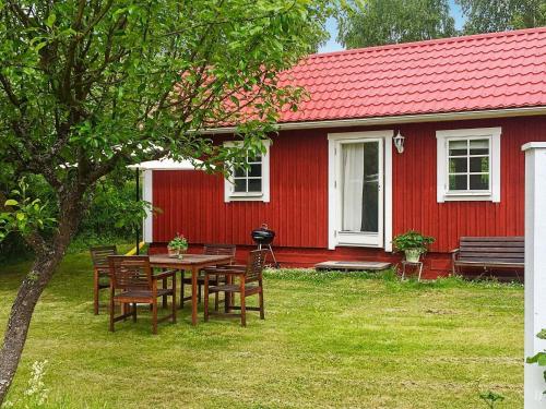 uma mesa e cadeiras em frente a uma casa vermelha em 4 person holiday home in STENHAMRA em Stenhamra
