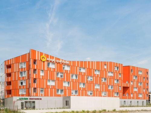 an orange building with a sign on top of it at Aparthotel Adagio Access Paris Massy Gare in Massy