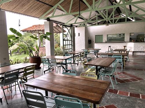 a group of tables and chairs in a restaurant at Waka Hotel Rural in Honda