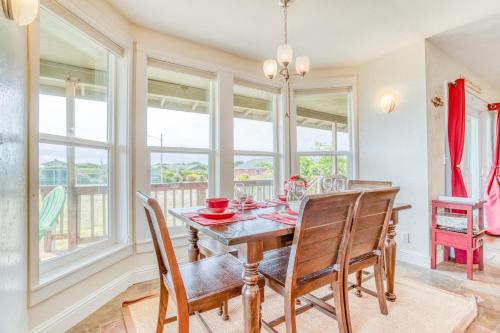 a dining room with a table and chairs and windows at Catamaran Cottage in Waldport