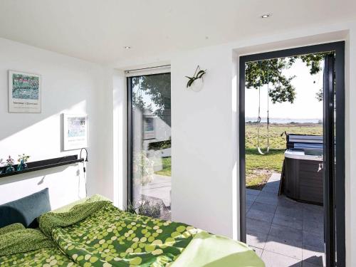 ÅrøsundにあるHoliday home Haderslev IIのベッドルーム1室(ベッド1台付)、スライド式ガラスドアが備わります。