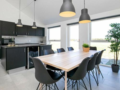 cocina y comedor con mesa de madera y sillas en 6 person holiday home in L kken, en Løkken