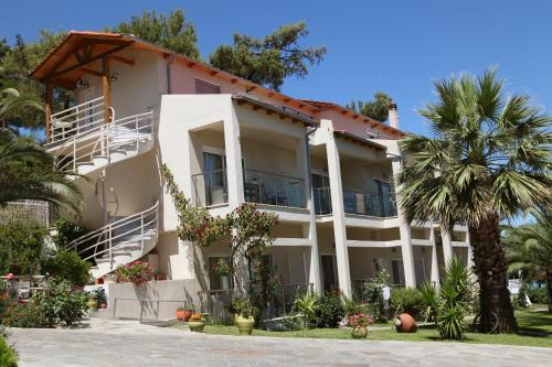 a large building with palm trees in front of it at Tarsanas Studios in Limenas