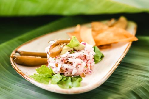 a plate of food with a salad and french fries at Igloo Beach Lodge in Manuel Antonio