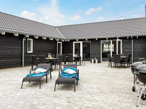 a patio with chairs and tables and a building at 20 person holiday home in Hasselberg in Kappeln