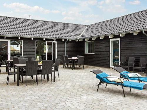 a patio with tables and chairs and a building at 20 person holiday home in Hasselberg in Kappeln