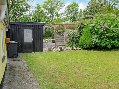 a backyard with a wooden gate and a garden at 4 person holiday home in Asaa in Aså