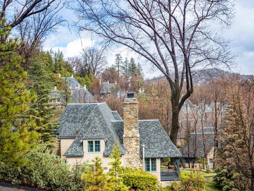 a house with a stone chimney on a hill at UCLA Lake Arrowhead Lodge in Lake Arrowhead