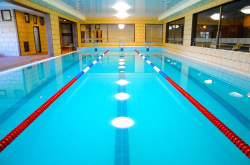 une grande piscine avec des couloirs bleus et rouges dans l'établissement Park Hotel Izida, à Dobritch